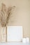 Dried pampas grass in vases, candles and felt letter board on beige background