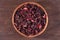 Dried petals of hibiscus in a wooden bowl