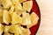 Dried pineapple chunks on red plate close view