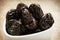Dried plums prunes in white bowl on wooden table