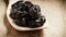 Dried plums prunes on wooden spoon