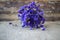 Dried purple wildflowers, wooden background.