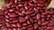 Dried red beans from a burlap bag close up full frame