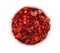 Dried red chili flakes in bowl, isolated on white background. Chopped chilli cayenne pepper. Spices and herbs. Top view.