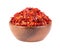 Dried red chili flakes in wooden bowl, isolated on white background. Chopped chilli cayenne pepper. Spices and herbs.