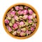 Dried rose buds in wooden bowl over white