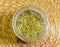 Dried rosemary herbs in a glass bowl.