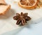 Dried round slices of lemon and apple as well as star anise on a blue background