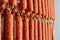 Dried sausage hanging on a rope on a metal frame in the smoke house.