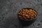 Dried seaberry buckthorn in black bowl on terrazzo countertop with copy space