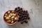 Dried shelled chestnuts on a marble plank with other freshly picked ones.