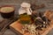 Dried sticks of licorice root, powder and essential oil on wooden table