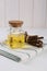 Dried sticks of licorice roots and essential oil on white table