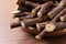 Dried sticks of liquorice root on wooden table, closeup