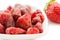 Dried strawberries in white bowl and fresh strawberry.