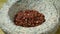 Dried szechuan or sichuan pepper in a stone mortar close up