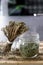 Dried thyme in glass jar and cut dried thyme bouquet on wooden board