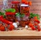 Dried tomatoes in oil, preserved chili in glass jars, ingredients