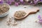 Dried Valerian roots in wooden spoon on sackcloth background. Va