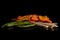 Dried vegetable chips isolated on black glass