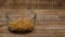 Dried yellow peas falling into a glass bowl.