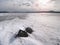 Drifting piece of iceberg and sun glaring on thick ice cover.