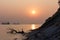 Driftwood and ships against the setting sun