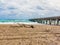 Driftwood , Turquoise Sea, Cloudy Sky and a Pier