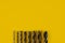 Drill bits of different sizes on yellow background,top view