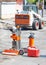 Drilling gasoline machine for cutting samples of asphalt concrete with a canister of fuel on the background of road machinery