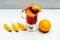 Drink or beverage with orange and cinnamon. Glass with mulled wine near juicy orange fruit on white background, close up