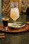 A drink consisting of Baileys liqueur and a drink of mineral water, sweet syrup with ice and a straw.