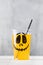 Drink in cup with funny spooky face and straw on table