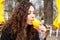 Drink fresh juice orange yellow girl coat curly hair smile street Netherland Hague sun spring brunette hand holding glass