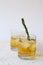 Drink in a glass with ice and a sprig of rosemary on a white background