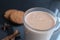 Drink hot chocolate cocoa in a glass mug with cinnamon sticks and cookies on a black background with a place for text