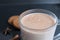 Drink hot chocolate cocoa in a glass mug with cinnamon sticks and cookies on a black background with a place for text