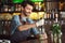 Drink Preparation. Bartender standing at counter squeezing out lime juice smiling joyful close-up