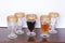 Drink, set of five gold rimmed glass goblets; photo on wooden background