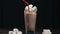 Drink tube is added to the glass with hot cocoa drink and marshmallows, making of cocoa with milk, drinking the hot