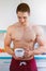 Drinking coffee bodybuilder man shirtless in the kitchen portrait format morning