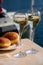 Drinking of French brut champagne sparkling wine with sweet apple Beignet, club party in yacht harbour of Port Grimaud near Saint-