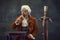 Drinking lemonade. Vintage portrait of young man in brown vintage suit and white wig like medieval royal hunter isolated