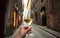 Drinking wine on street. Hand of a happy drinker in outdoor cafe of narrow historical area, enjoying alone