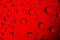 Dripped water on glass. Red abstract background