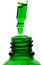 Dripping green facial serum from pipette into glass bottle on white background, closeup