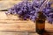 Dripping lavender essential oil into bottle on background. Space for text