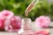 Dripping rose essential oil into bottle