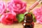 Dripping rose essential oil into bottle against blurred background