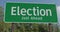 Drive past election just ahead green road sign.